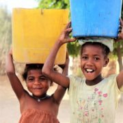 Local children carrying water