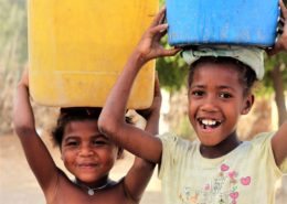 Local children carrying water